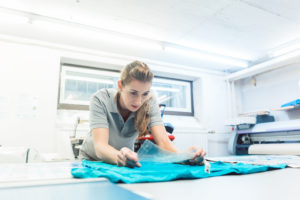 femme qui colle un logo sur t-shirt